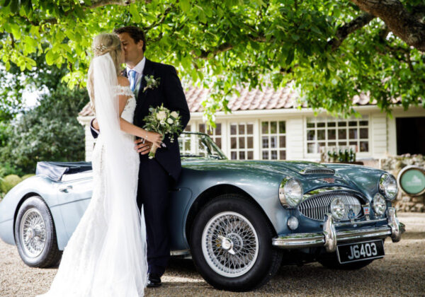 Couple kissing next to Classic Car at La Mare Wine Estate